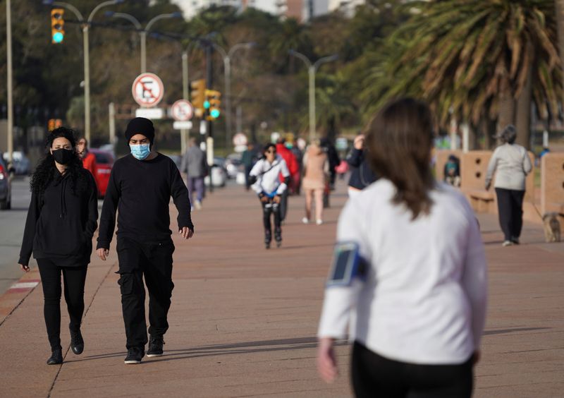 © Reuters. Pessoas caminham em calçadão de Montevidéu