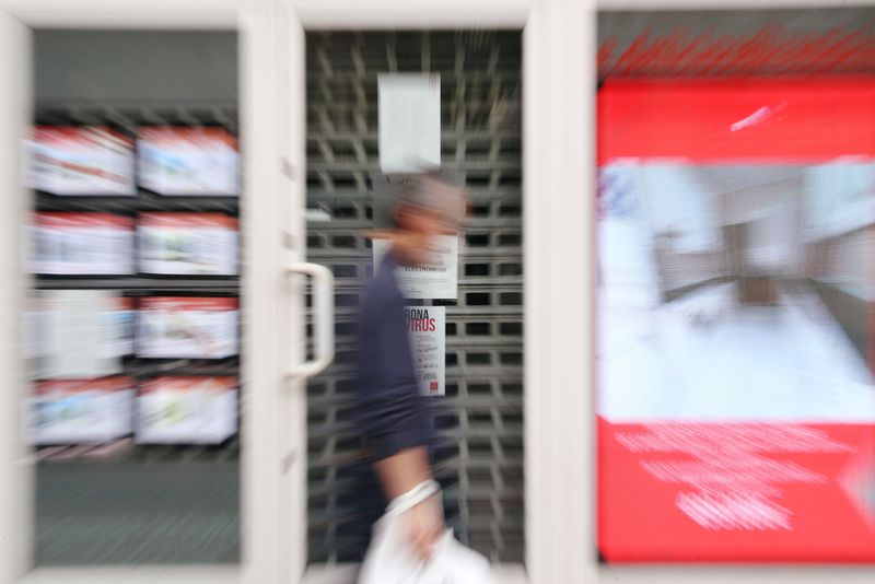 &copy; Reuters. FILE PHOTO: A man walks past a real estate agency during the coronavirus disease (COVID-19) outbreak in Madrid