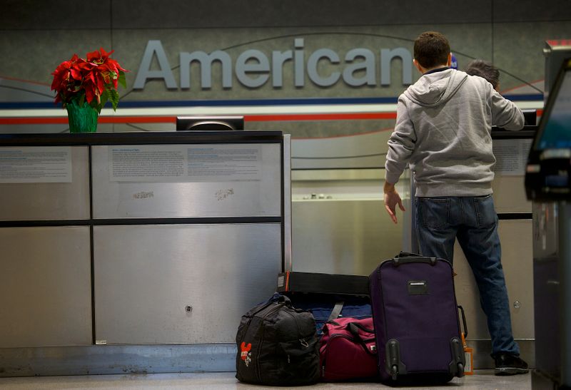 &copy; Reuters. FILE PHOTO:  A man checks in his luggage at the American Airlines check-in counter at Philadelphia International Airport