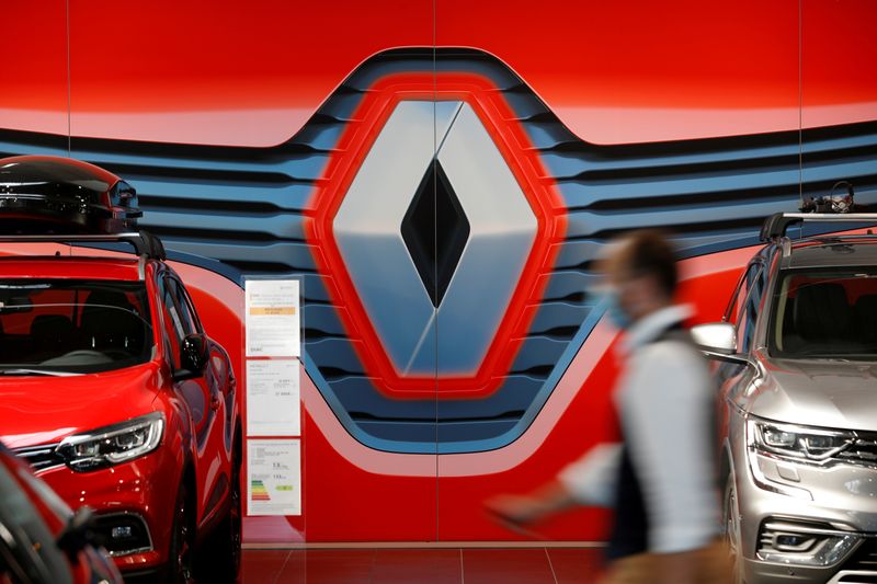 © Reuters. FILE PHOTO: An employee walks past a logo of Renault carmaker at a dealership in Nantes