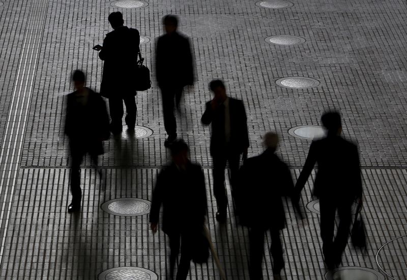 &copy; Reuters. FILE PHOTO: People walk at an office building at a business district in Tokyo