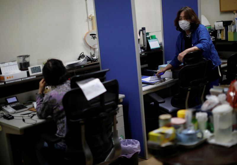 &copy; Reuters. Machiko Nakayama, director of the Tokyo Befrienders call center,  and a volunteer handle an incoming call during the spread of the coronavirus disease (COVID-19) continues, in Tokyo