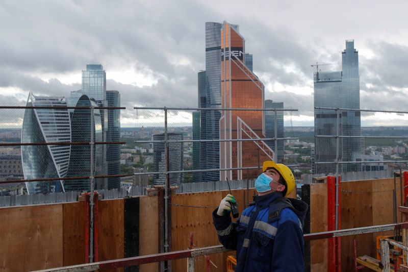 © Reuters. Рабочий в защитной маске на стройплощадке в Москве