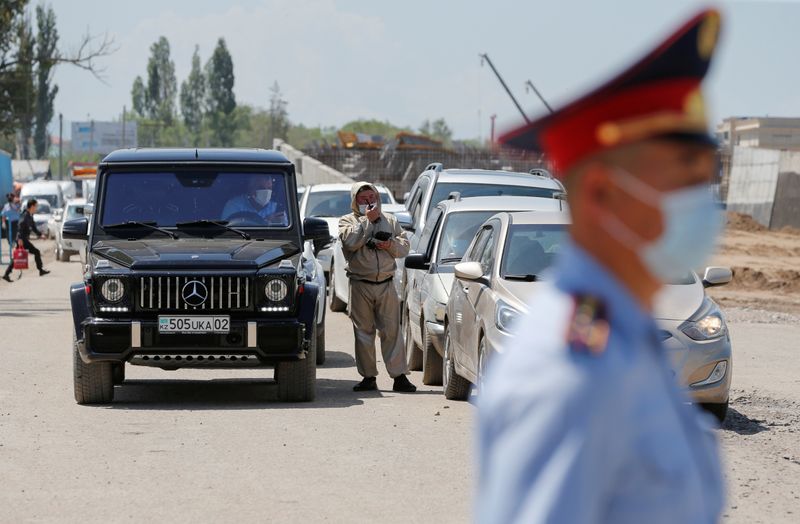 &copy; Reuters. Полицейские в защитных масках на КПП на окраине Алма-Аты