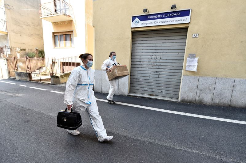 &copy; Reuters. Due operatori erogano prestazioni sanitarie mediche a domicilio a Oleggio, 23 aprile 2020