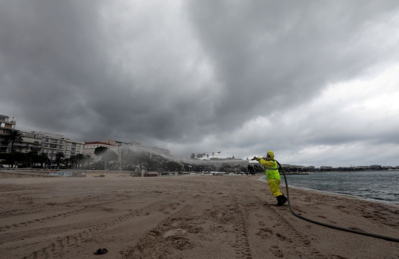 &copy; Reuters. FOTO DE ARCHIVO: Un equipo de desinfección rocía desinfectante para limpiar la playa de la Croisette en Cannes