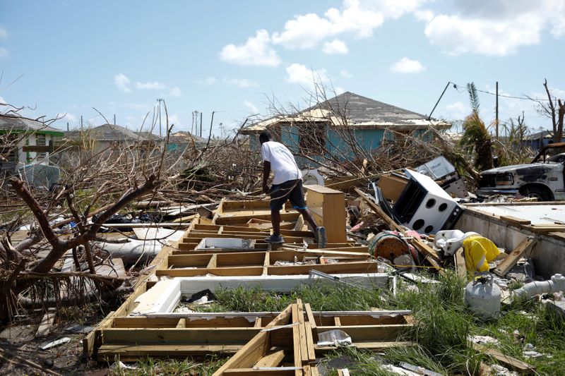 © Reuters. FILE PHOTO: A man walks among the debris of his house after Hurricane Dorian hit the Abaco Islands in Spring City