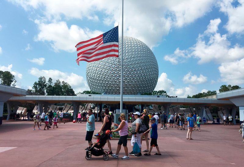 &copy; Reuters. Visitors walk pass a Stars and Stripes flying half-staff at the entrance to the Epcot Center at Walt Disney World resort in Orlando