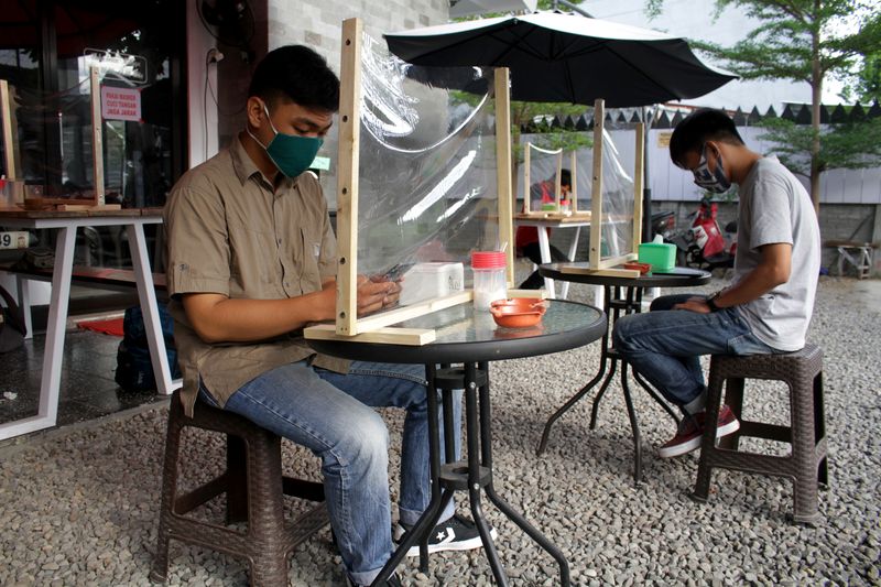 &copy; Reuters. FILE PHOTO: Customers sit with plastic dividers at a cafe to prevent at a cafe the spread of coronavirus disease (COVID-19) outbreak