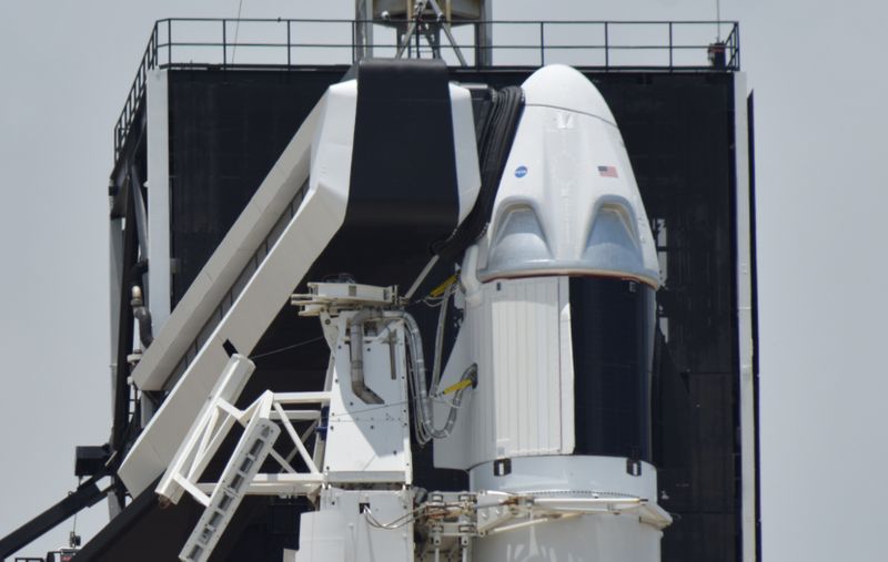 &copy; Reuters. FILE PHOTO: The SpaceX Crew Dragon spacecraft, atop a Falcon 9 booster rocket, is connected to the crew access arm and launch tower on Pad39A