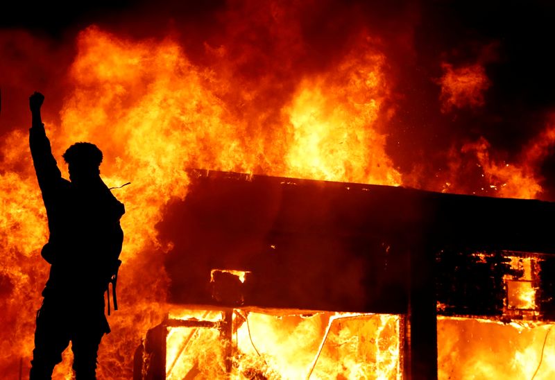 © Reuters. Un manifestante hace un gesto frente al fuego durante una protesta por la muerte del afroamericano George Floyd en Minneapolis