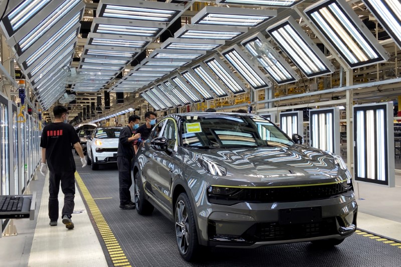 © Reuters. FILE PHOTO: Employees wearing face masks work on a Lynk &Co car production line at Geely's Yuyao plant in Ningbo