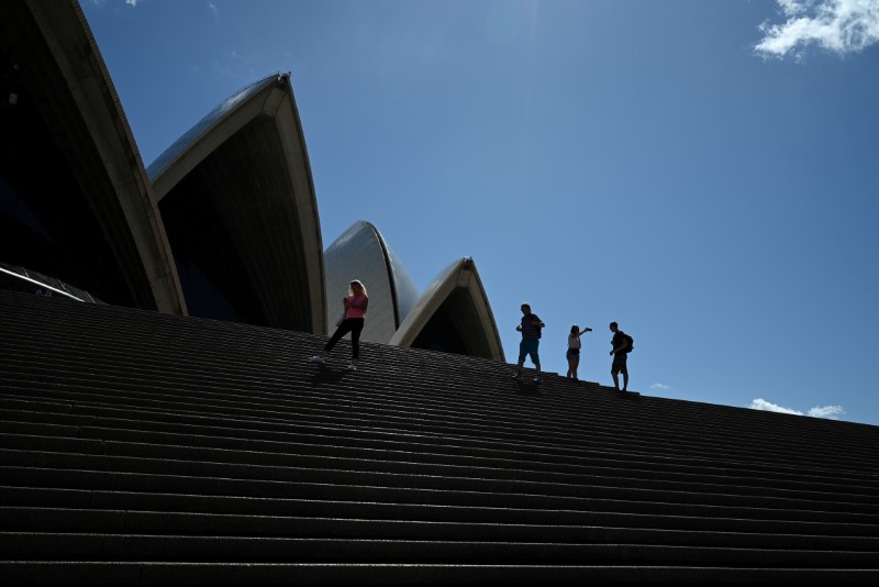 &copy; Reuters. FILE PHOTO: A handful of tourists stand atop the mostly deserted steps of the Sydney Opera House in Sydney
