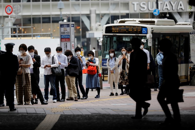 &copy; Reuters. FOTO DE ARCHIVO: Personas con mascarilla hacen cola mientras esperan un autobús cerca de la estación de Shibuya en Tokio, Japón, el 27 de mayo de 2020