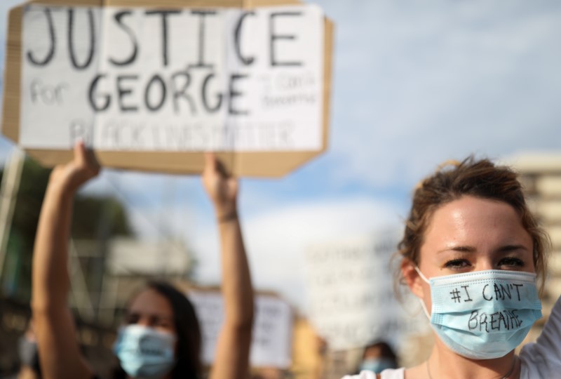 &copy; Reuters. Personas con mascarillas durante una protesta contra la muerte bajo custodia policial de George Floyd en Minneapolis, frente a un consulado de Estados Unidos, en Barcelona, España, el 1 de junio de 2020.