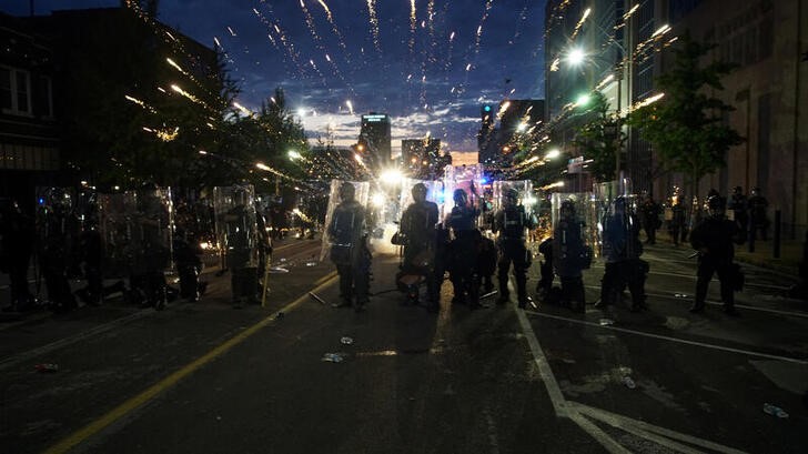 &copy; Reuters. Fogos de artifício são disparados atrás de policiais durante protesto em Mineápolis, EUA