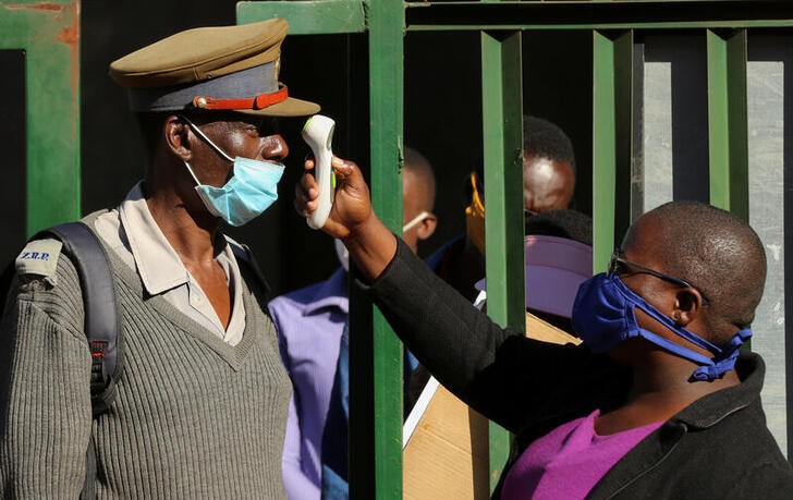 &copy; Reuters. FILE PHOTO:  A person checks a policeman&apos;s temperature during a nationwide lockdown to help curb the spread of the coronavirus disease (COVID-19) in Harare
