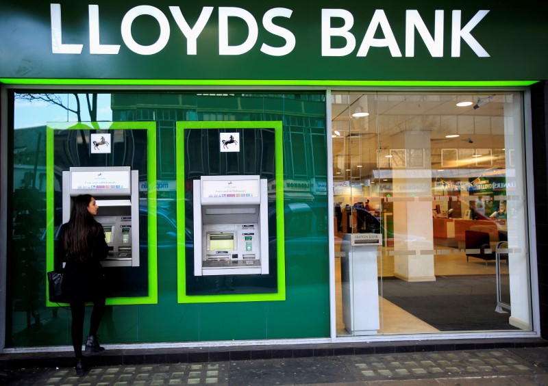 &copy; Reuters. FILE PHOTO: A woman uses a cash machine at a Lloyds Bank branch in central London
