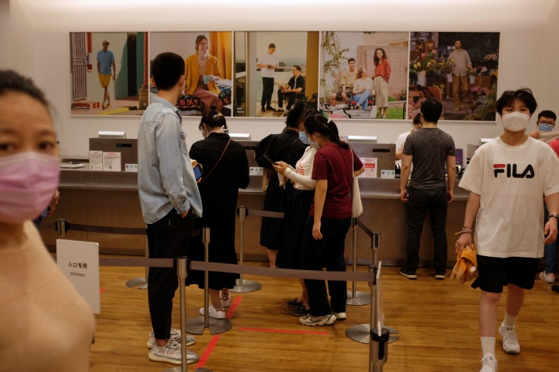 © Reuters. Customers line up at a payment counter inside a store of the Fast Retailing's fashion chain Uniqlo, in Beijing