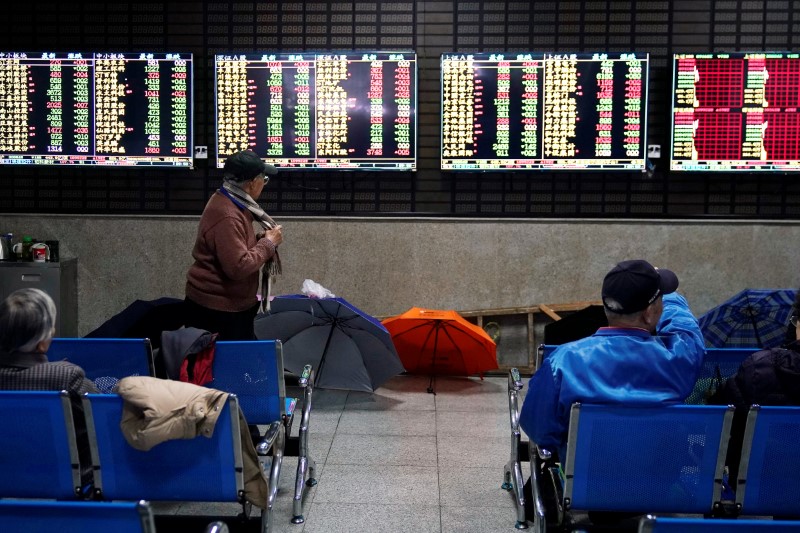 &copy; Reuters. Investors look at screens showing stock information at a brokerage house in Shanghai