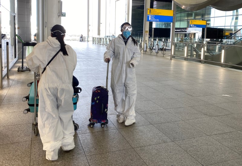 &copy; Reuters. Passengers wearing protective clothing are seen at Heathrow Airport, London