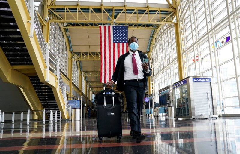 &copy; Reuters. FILE PHOTO: Passenger walks through Reagan National airport as air travel continues to be minimal in Washington