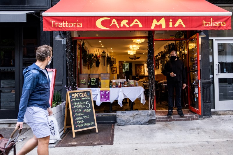 &copy; Reuters. Garçom com máscara na porta de restaurante em Manhattan