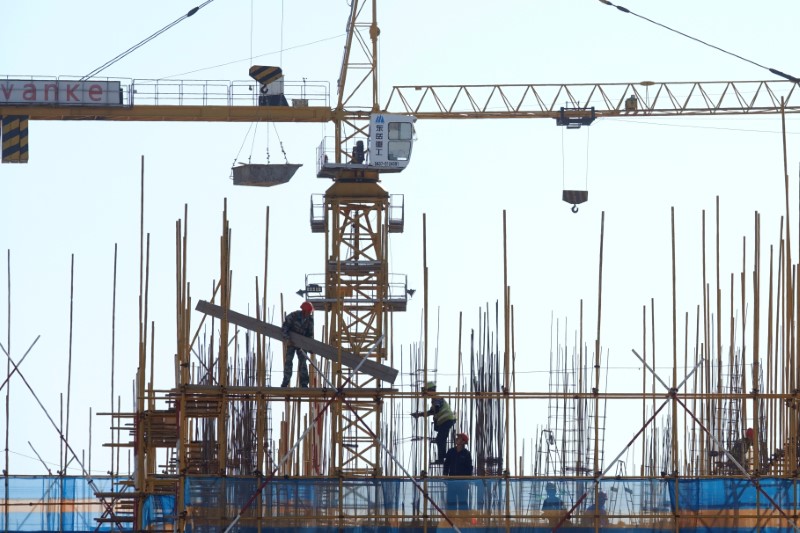 &copy; Reuters. Vanke sign is seen above workers working at the construction site of a residential building in Dalian