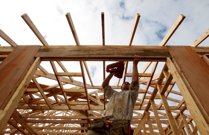 &copy; Reuters. FILE PHOTO: A tradesman uses a nail gun on the framework of a new house on the outskirts of Melbourne
