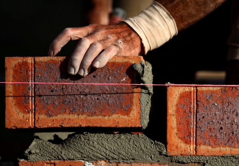 © Reuters. FILE PHOTO: Bricklayer places a brick in the wall of a new house in a Sydney suburb