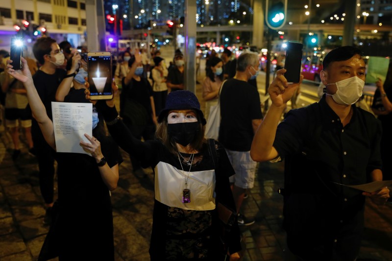 &copy; Reuters. Varias personas con mascarillas protectoras levantan sus teléfonos móviles en Hong Kong
