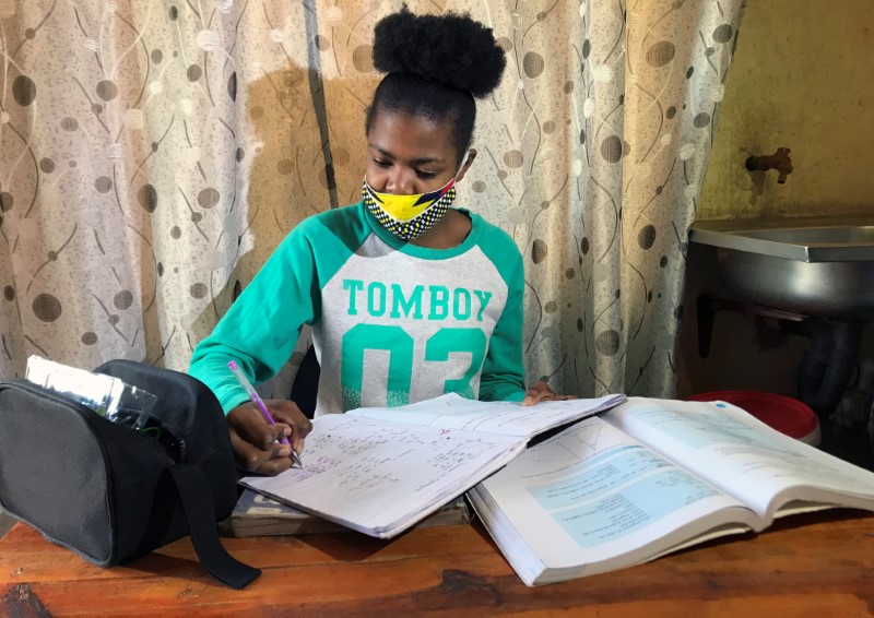 © Reuters. Learner Phuti Ngoetjana tries to study math at her family's one-room brick home during COVID19 outbreak in Tembisa