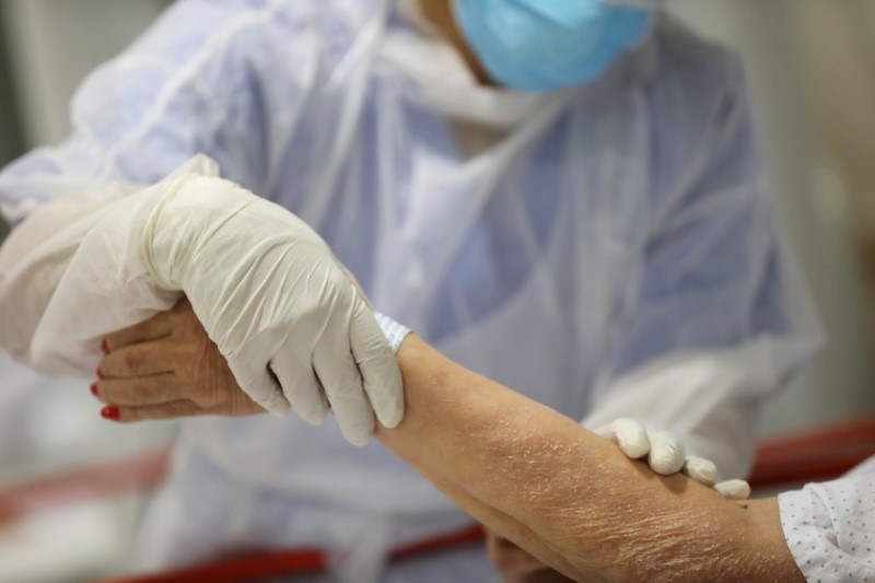 © Reuters. FOTO DE ARCHIVO de una sanitaria con una paciente en un hospital de Madrid