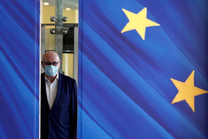 &copy; Reuters. FILE PHOTO: A man wearing a face mask walks past the European Commission headquarters as the spread of coronavirus disease (COVID-19) continues in Brussels