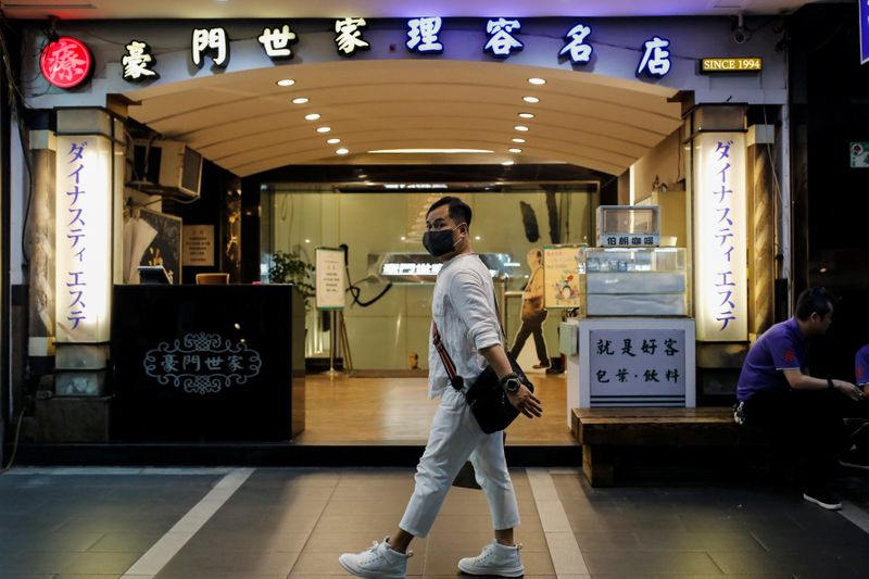 &copy; Reuters. A person wearing a face mask as a preventive measure against the coronavirus disease (COVID-19) walks past Dynasty massage parlour in Taipei