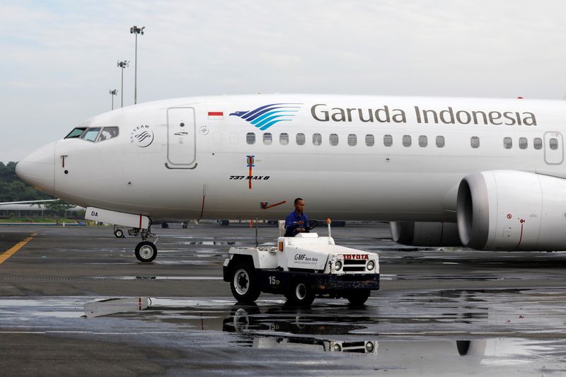 &copy; Reuters. FILE PHOTO: A technician rides a car as he passes Garuda Indonesia&apos;s Boeing 737 Max 8 airplane parked at the Garuda Maintenance Facility AeroAsia, at Soekarno-Hatta International airport near Jakarta