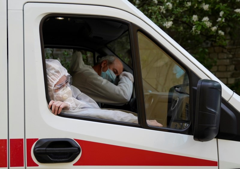 &copy; Reuters. Врач скорой помощи и водитель ждут разрешения проехать на территорию больницы в Твери