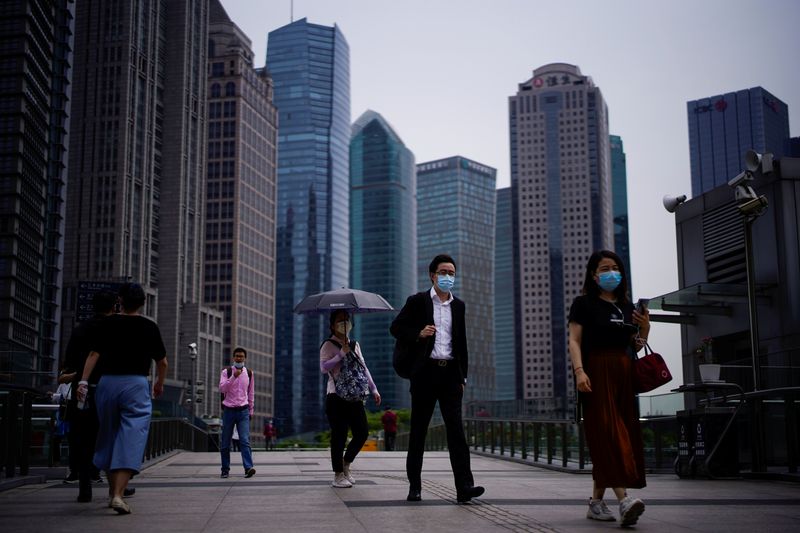 &copy; Reuters. Люди в масках в финансовом районе Шанхая