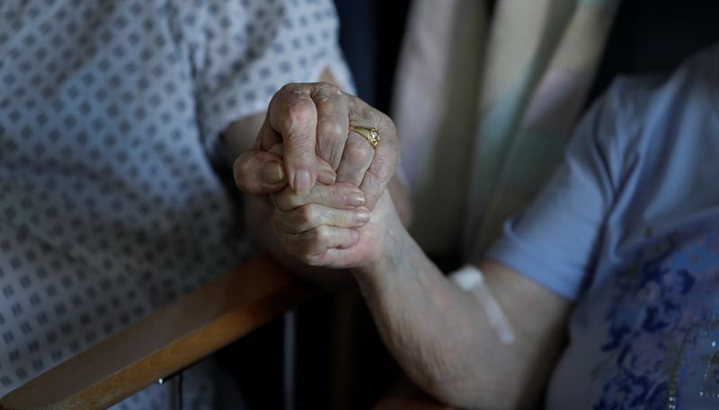 &copy; Reuters. Pacientes idosos seguram as mãos durante breve visita em hospital de Cambridge