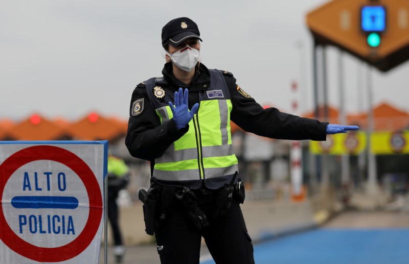 &copy; Reuters. FOTO DE ARCHIVO: Un policía de fronteras hace un gesto mientras revisan los vehículos en el último peaje que entra a España desde Francia en La Jonquera, España, el 17 de marzo de 2020