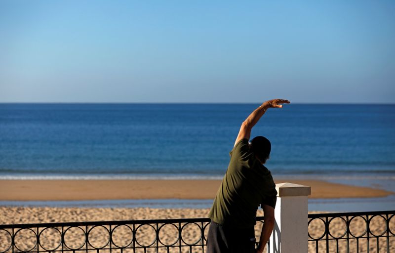 &copy; Reuters. Man excersises at the beach in Praia da Luz