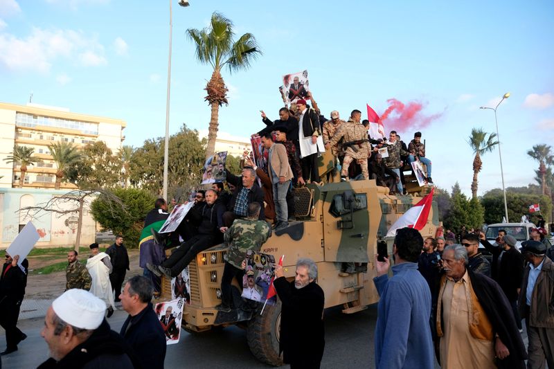 © Reuters. FILE PHOTO: Supporters of Libyan National Army (LNA) commanded by Khalifa Haftar, celebrate on top of a Turkish military armored vehicle, which LNA said they confiscated during Tripoli clashes, in Benghazi