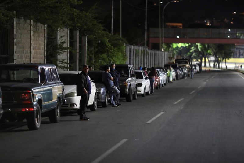 © Reuters. People wait outside their cars at a queue to refill gasoline at a gas station with subsidized fuel in Caracas