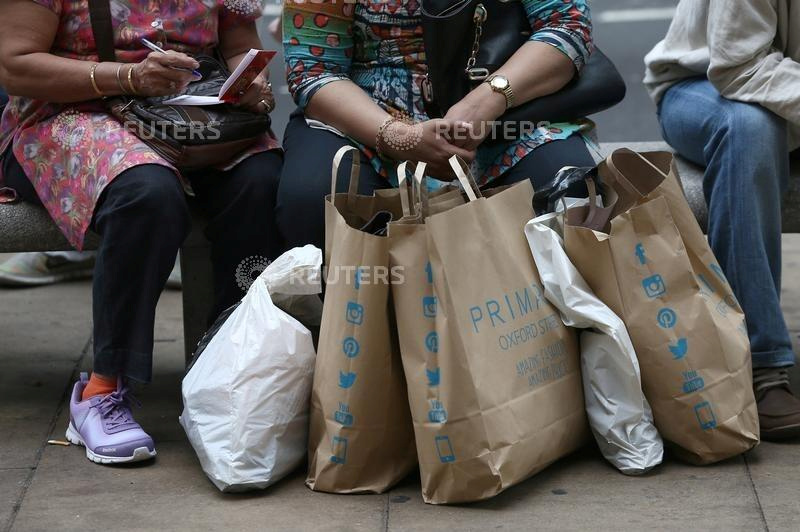 &copy; Reuters. FILE PHOTO: Shoppers sit with bags in London