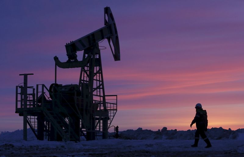&copy; Reuters. File photo of a worker walking past a pump jack on an oil field owned by Bashneft, Bashkortostan