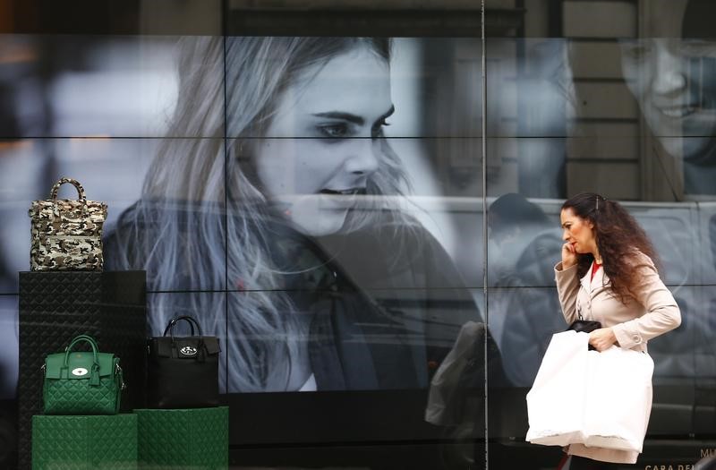 &copy; Reuters. A woman walks past a video display in the shop window of a Mulberry store in central London