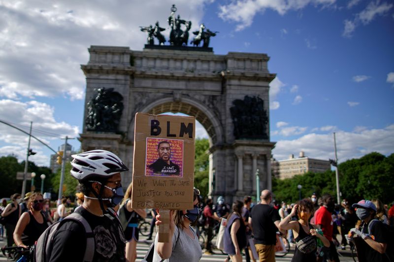 &copy; Reuters. A demonstrator holds a sign during a protest against racial inequality in the aftermath of the death in Minneapolis police custody of George Floyd, at Grand Army Plaza in the Brooklyn borough of New York City