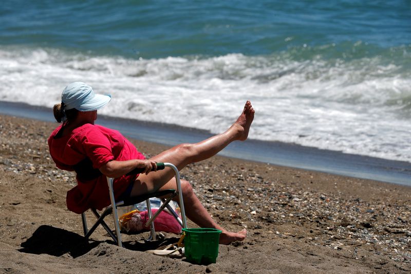 &copy; Reuters. Mulher toma sol em praia da Espanha