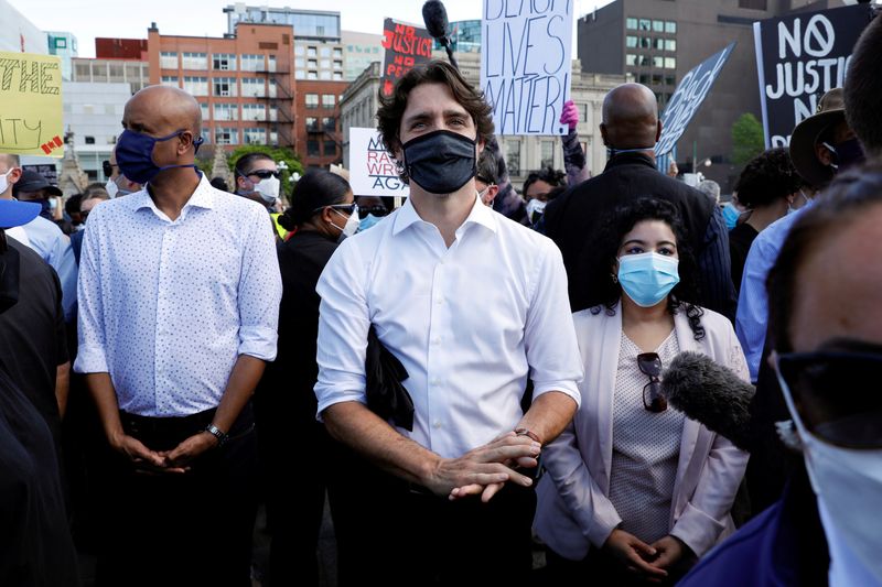 &copy; Reuters. FILE PHOTO: Canada&apos;s Prime Minister Justin Trudeau rubs hand sanitiser on his hands, given to him by a protestor, while taking part in a rally against the death in Minneapolis police custody of George Floyd, on Parliament Hill, in Ottawa