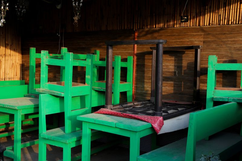 © Reuters. FILE PHOTO: Tables are seen lying on each other in a restaurant which is closed during an extended nationwide lockdown to slow down the spread of the coronavirus disease (COVID-19), in New Delhi